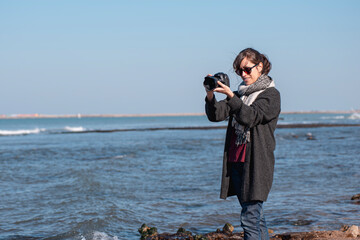 woman taking photos at the beach
