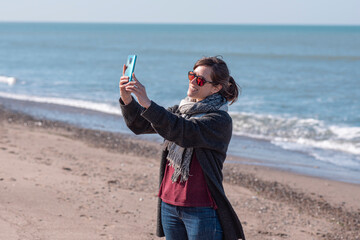 woman playing on the beach, selfie on the beach