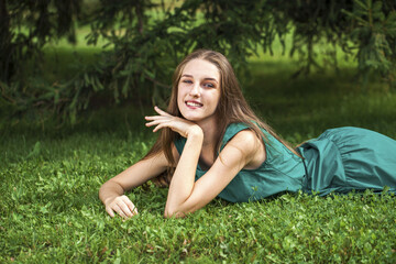 Portrait of a young girl lying on green grass