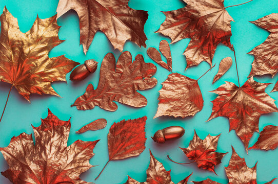 Top view of golden leaves on turquoise background