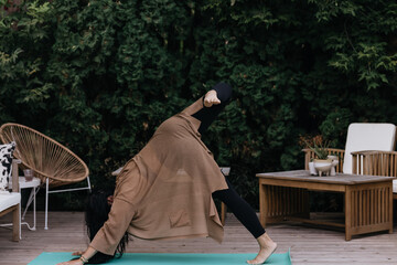 Young adult filipino woman practicing yoga and meditation outdoors at home