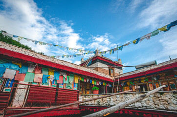 Fototapeta na wymiar Traditional artistic Tibetan houses hanging with prayer flags for sending blessings