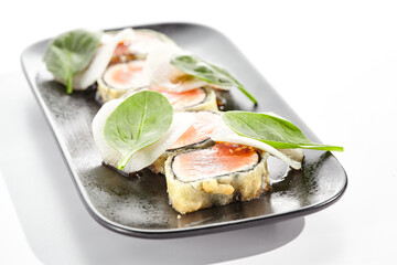 Salmon tataki - seared salmon. thinly sliced sashimi style. Salmon tataki served with delicious citrus ponzu tataki sauce. Japanese seafood on black plate isolated on white background.