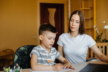 A mother and her child are engaged in distance learning at home in front of the computer. Stay at home, training