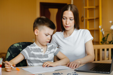 A mother and her child are engaged in distance learning at home in front of the computer. Stay at home, training