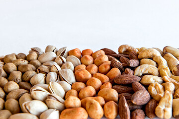 Healthy snack, beans, pistachios, Brazil nuts, chickpeas, peanuts and almonds on white background.