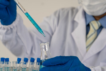 a professional scientist or researcher holding a test tube The pipette lowers the sample into the test tube. by virus analysis Corona COVID-19 in the near term scientific laboratory test
