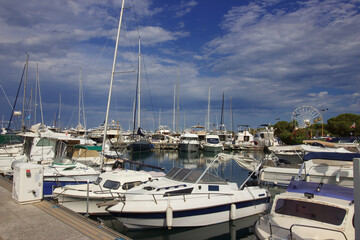 Fototapeta na wymiar Le port d'Antibes avec ses bateau et la grande roue sur la place dans l'arrière plan