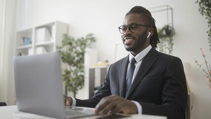 African male in business suit having online interview on laptop, pandemic time