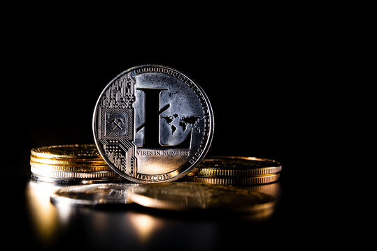 Silver litcoin with various physical metal coins on dark background. Cryptocurrency concepts.