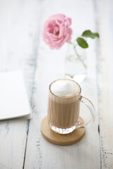 Latte and rose flower with notebook on vintage old white table