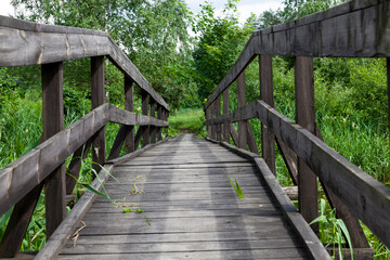 Fototapeta na wymiar old wooden bridge built on the lake
