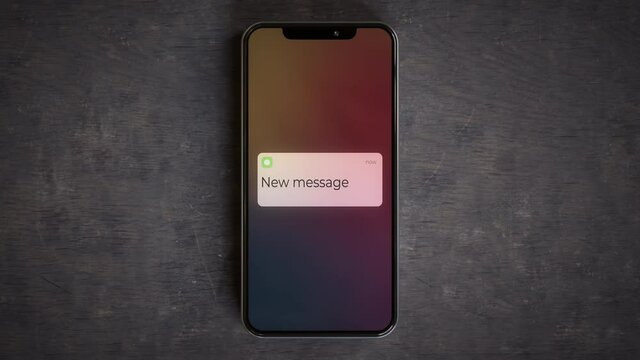Smartphone on a desk showing new message lockscreen notification 4k