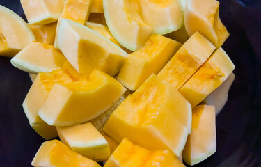 The piece of rip cantaloupe on the plate for the dessert bar in the restaurant.