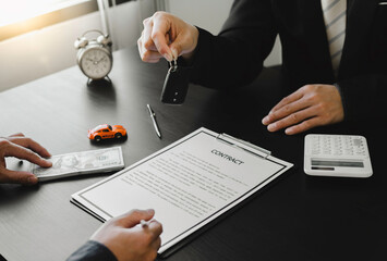 Sale agent giving Car key to customer and sign agreement contract, Insurance car concept.