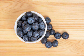 Fresh blueberry in white dish on wooden background