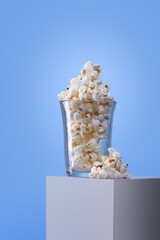 crystal glass with popcorn on a white box and a blue background