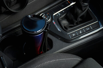 Eco cup with coffee in holder inside car
