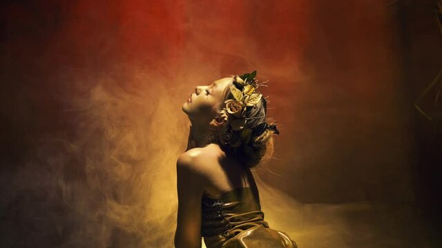 Silhouette of mysterious fantasy woman goddess. Gold skin dress hair. girl fashion model posing in studio. Backdrop sparkling mystical yellow smoke magic fog dark gothic room. Living art sculpture 4k 