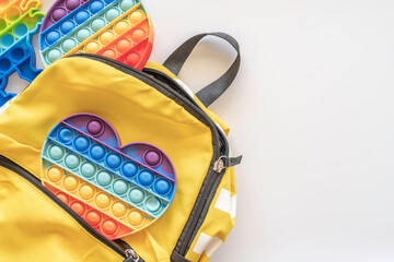 Sensory Fidget Toy and school bag on white background. - obrazy, fototapety, plakaty