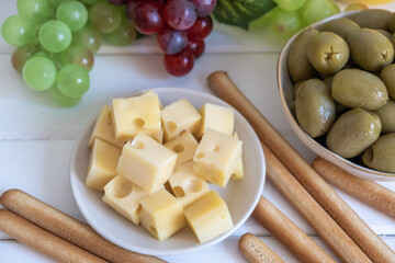 Hard cheese, green olives and Grissini bread sticks. Mediterranean snacks.