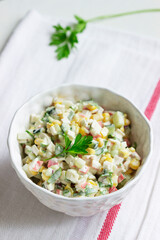 Vegetable salad with crab sticks, dressed with mayonnaise.