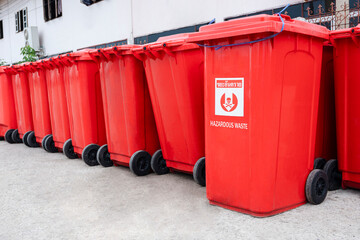 Rows of many red hazardous waste bins were arranged neatly outside the field hospital for hygienic disposal during Covid 19 pandemic at Thailand, Thai language of sign is mean "Hazardous waste"