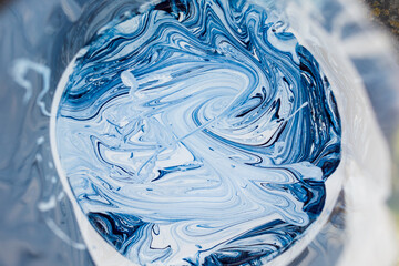stains of blue color scheme in a jar with white paint, abstract background