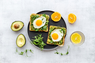 Open sandwich with eggs and avocado on plate. Overhead view
