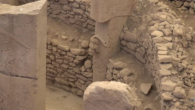 Gobeklitepe, Sanliurfa, Turkey - 15th of June 2021: 4K Zoom out well preserved tiger and pig animal relieves on the stone pillars
