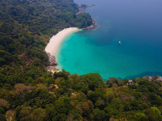 Obraz premium Aerial view top-down of Drone camera over white beach sand and sew water clear. Nature video view of beautiful tropical beach and sea in sunny day. Palm tree at beach. At Phuket, Thailand.