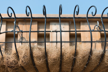 wire planter with coconut liners screwed securely to a wooden plank fence - obrazy, fototapety, plakaty