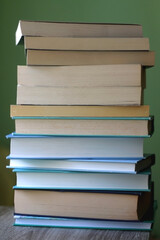 Stack of books with blue and green covers. Selective focus.