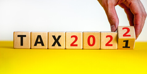 2022 tax new year symbol. Businessman turns wooden cubes and changes words 'Tax 2021' to 'Tax 2022'. Beautiful white background, copy space. Business, 2022 tax new year concept.