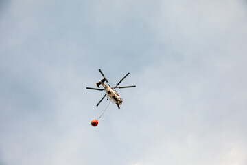 fire fighting helicopter leaves water to the forest fire