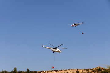fire fighting helicopter leaves water to the forest fire