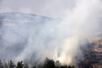 fire fighting helicopter leaves water to the forest fire