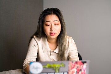 Young Edgy Female Asian Data Scientist on a Video Conference