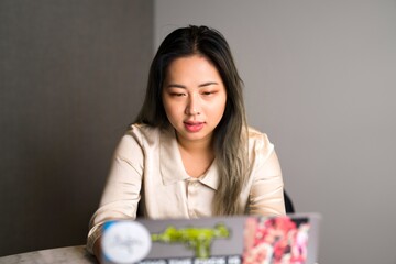 Young Edgy Female Asian Data Scientist on a Video Conference