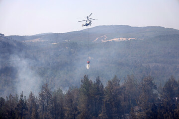 Fototapeta na wymiar fire fighting helicopter leaves water to the forest fire