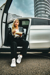 business lunch in the car. girl eating fast food on the road
