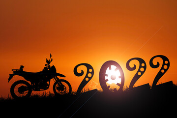 Silhouette motocross adventure traveler with a motorcycle. happy new year 2022