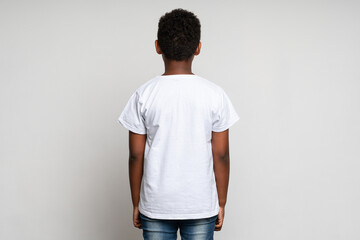 Back view of the multiracial boy wearing white T shirt. Childhood concept. Isolated on white...