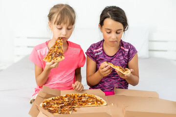 Two pretty young girls eating a slice of pizza