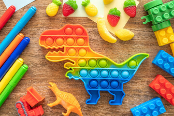 Sensory Fidget Toy in the form of octagon, kid repair tools, chocolate coins, cup of juice over wooden background. Anti stress concept.