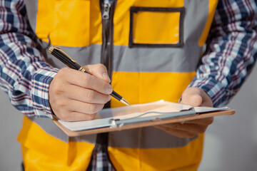 building contractor Check and write down the details of the construction. wearing yellow construction clothes house construction contractor concept