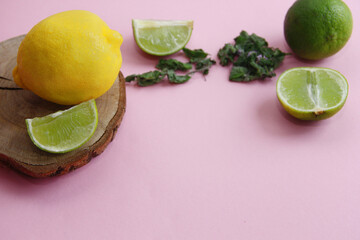 Lemon, lime, mint and juicy lime slices on a wooden plate on a bright background