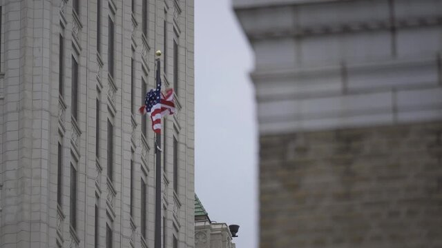 An American flag waves from the top of a building in downtown Tulsa, Oklahoma.  This is a close up shot.