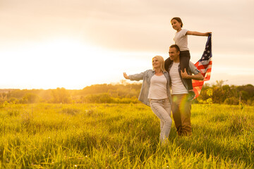 Happy family in wheat field with USA american flag on back.