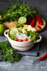 Vietnamese pho soup with chicken. Asian dish with rice noodles, meat and lime. pho ga with chili pepper. Asian cuisine. Food styling of soup. Serving Vietnamese cuisine